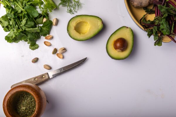 Fresh chopped vegetables and avocados arranged colorfully on a white surface for healthy meals.