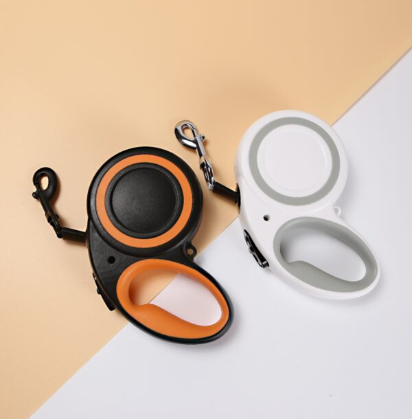 Modern retractable dog leashes in black with orange and white with grey accents.