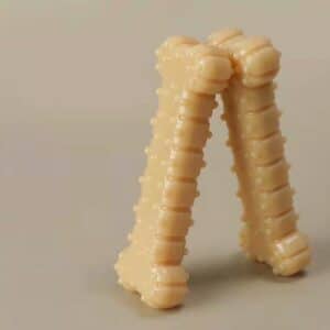 Playful beige sculpture resembling legs, featuring a glossy finish and intriguing tactile ridges.