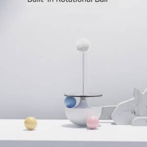 Playful modern sculpture with rotational ball and pastel spheres on a minimalist gray background.