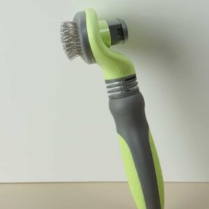 Ergonomic lime and gray pet grooming tool with flexible bristles for effective fur removal.